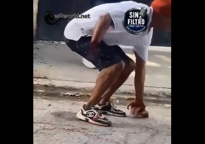 He is trying to retrieve his severed hand after someone else cut it off with a machete